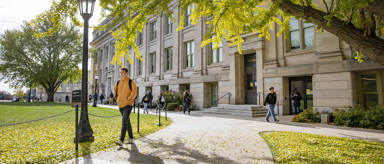 Students walking in front of MacClean Hall on an autumn day