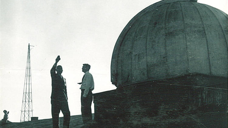 Two men standing next to the MacLean Hall Observatory in the 1930s